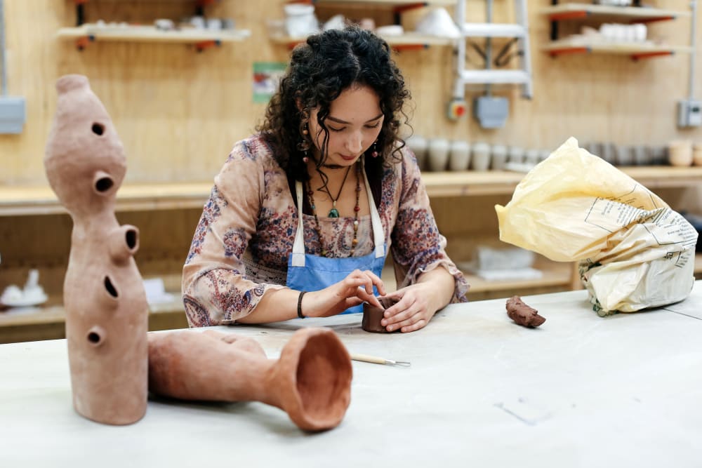 Woman making ceramic vessels in the studio