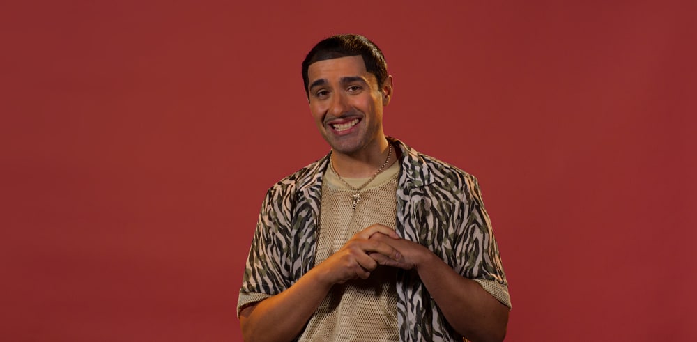 Photo of a man in a string vest smiling