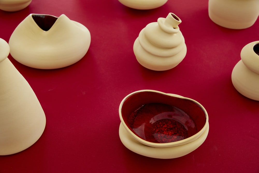 White ceramic pots and vases on a red table top