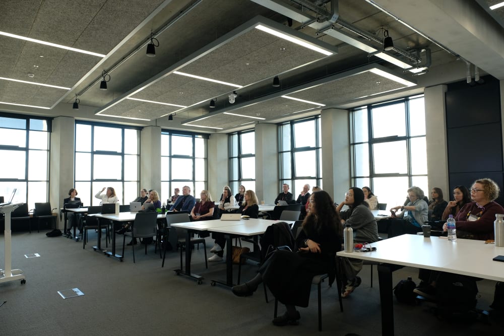 People sitting around tables in a classroom.