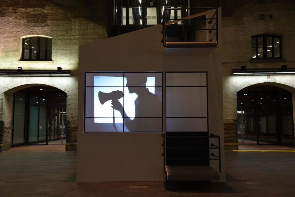 Projection of person with speakerphone against window