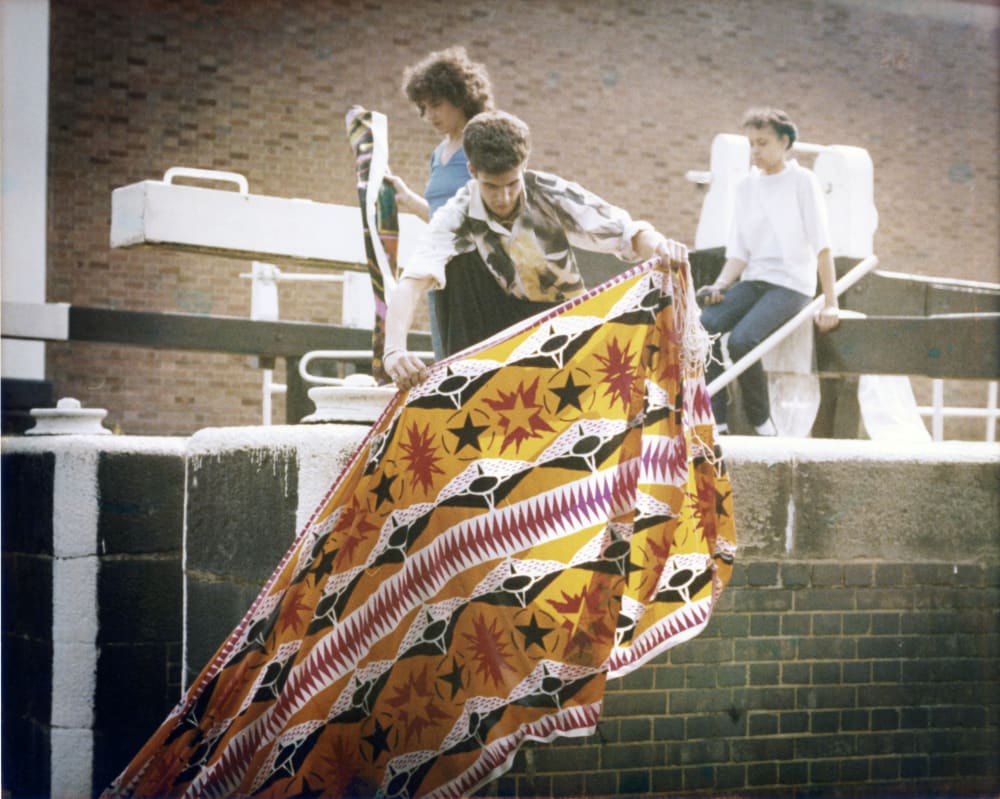 A young man with a piece of printed colorful fabric