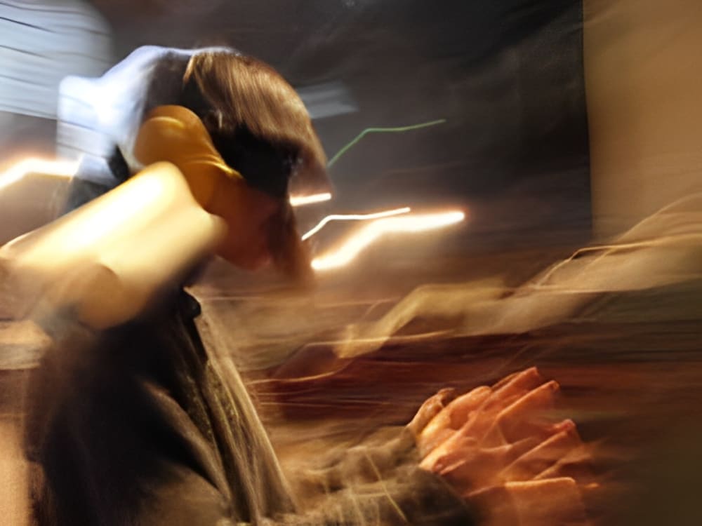 A blurred colour photograph of a person standing and wearing a headpiece.