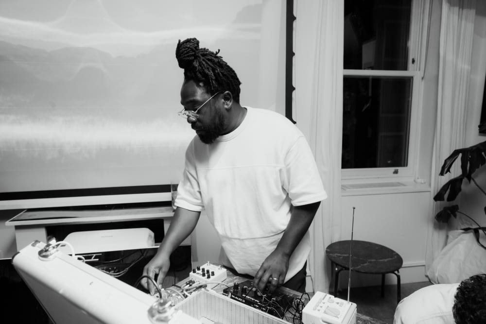 Black and white image of a man at a audio set-up