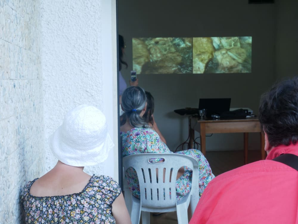 people sat on plastic chairs watching a film