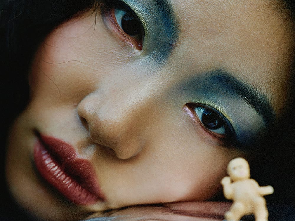 A close-up of a model wearing makeup and staring straight into the camera.
