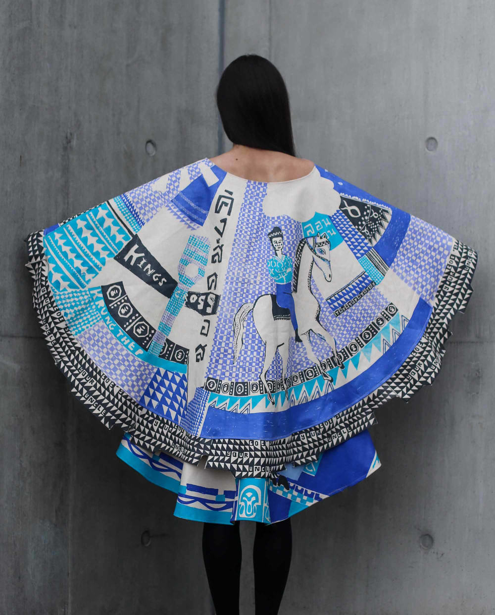 Figure wearing blue and white cape