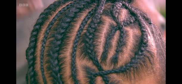 Image of the top of a girls head with canerows