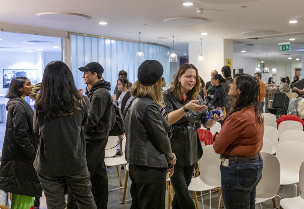 Networking after the event, lots of groups of people speaking with drinks