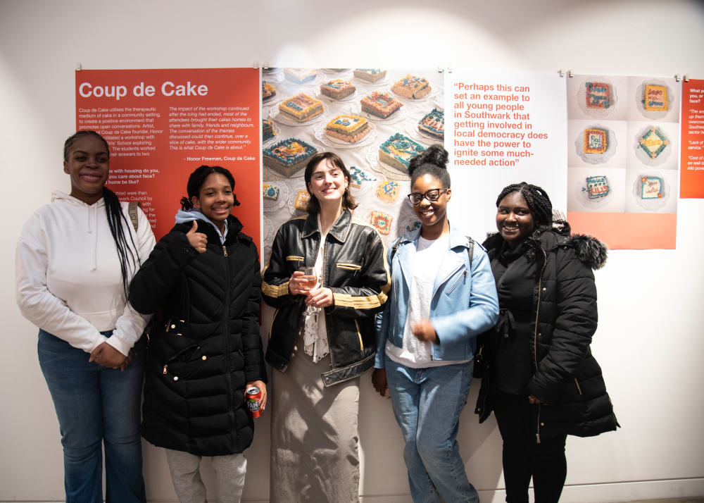 Five young participants in the Camberwell College x Citizens UK workshop, standing in front of an exhibition display