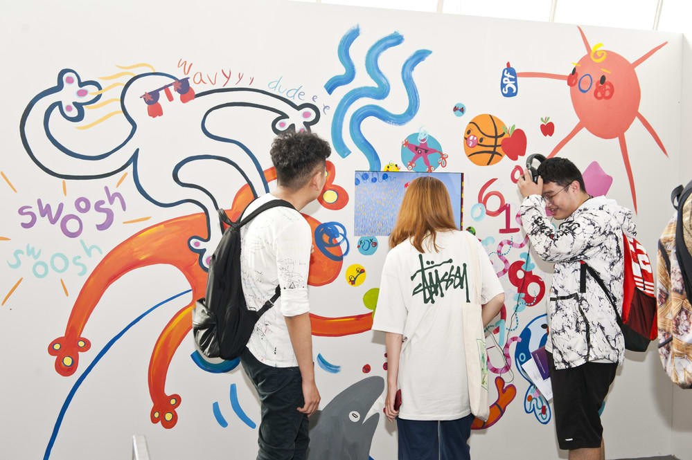 Students engaging with a video at the Degree Show