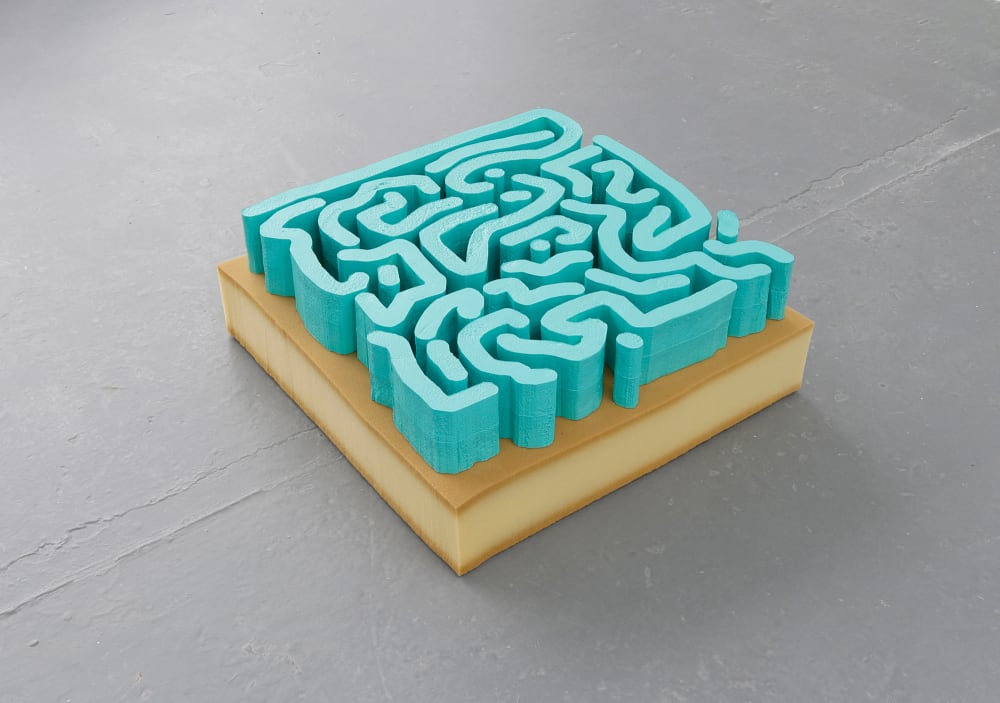 a blue sculpture displayed on a brown plinth