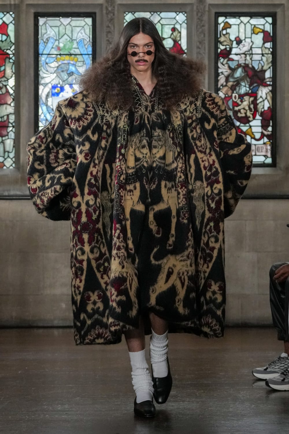 Model on catwalk wearing a patterned dress