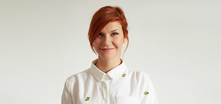 Photo head-shot of Lisa Matzi, wearing a white shirt with green cacti.
