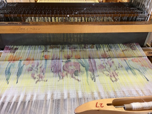 A weave machine weaving colourful patterned fabrics