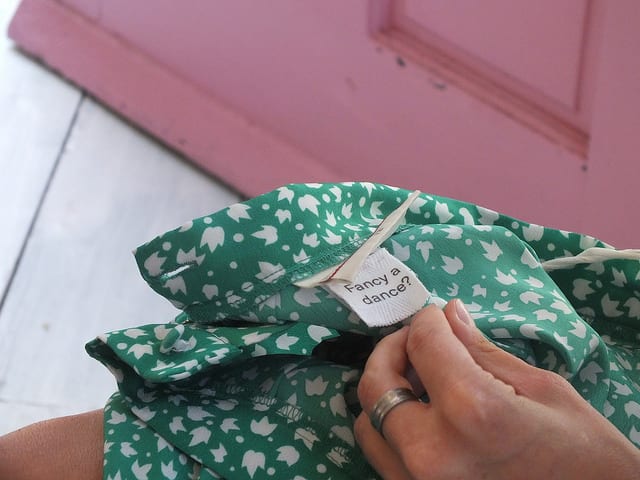A green shirt with a tag sewn into it saying