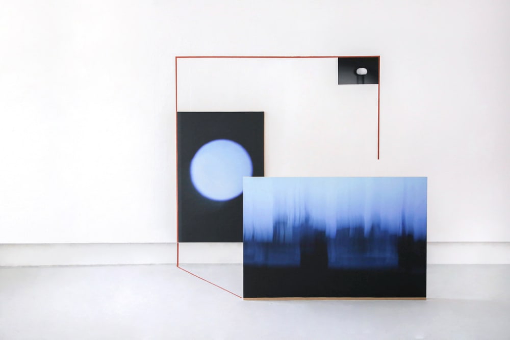 Installation view of two 2D blue and white images in a red square