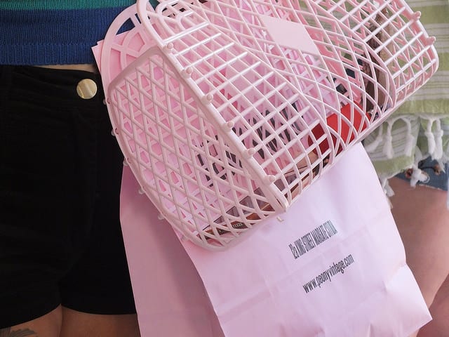 A woman holding a pink net shopping bag.