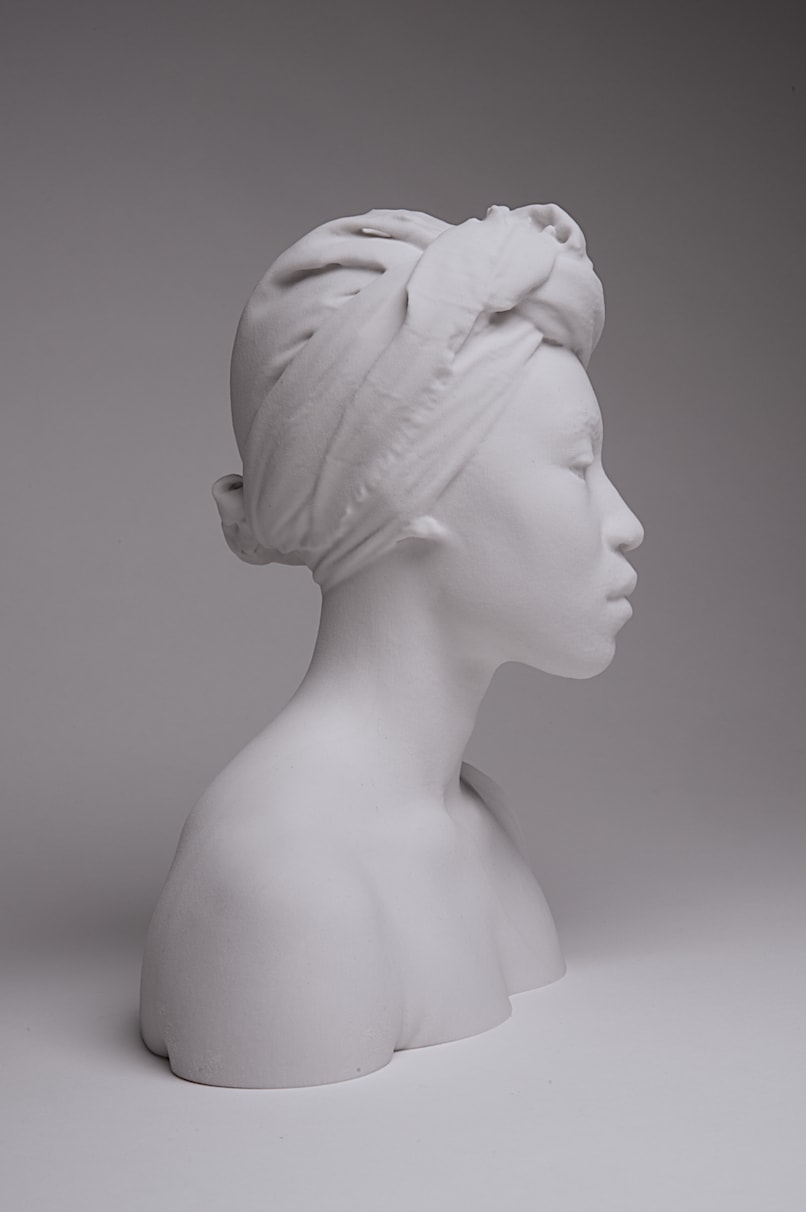 a studio shot of a white concrete bust