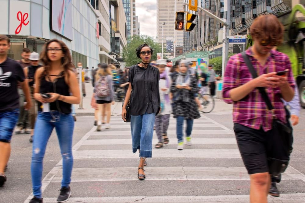 a photograph of people walking across a zebra crossing