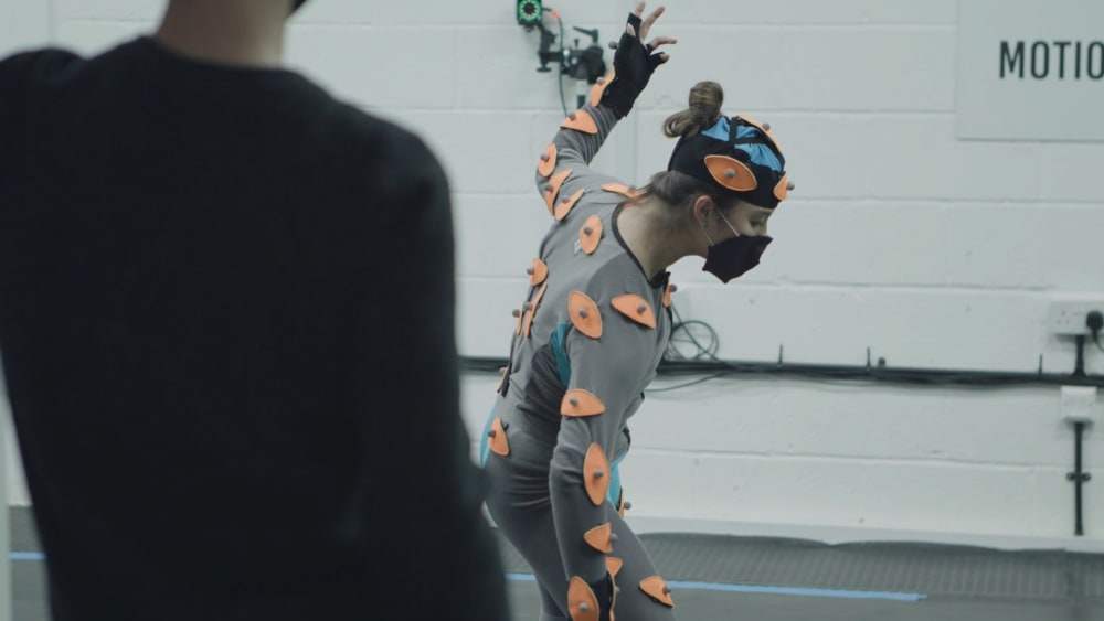 Young woman dancing in a body suit with sensrors