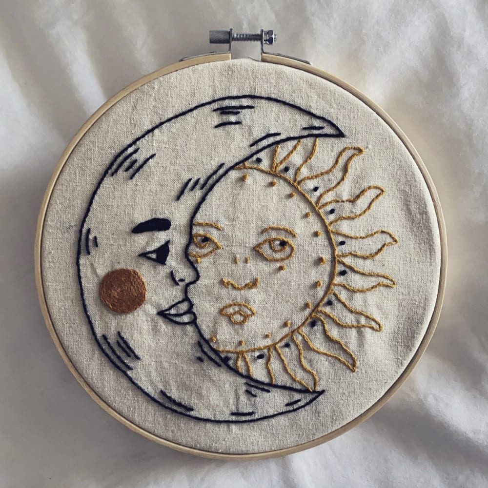 an embroidery image of a sun and a moon