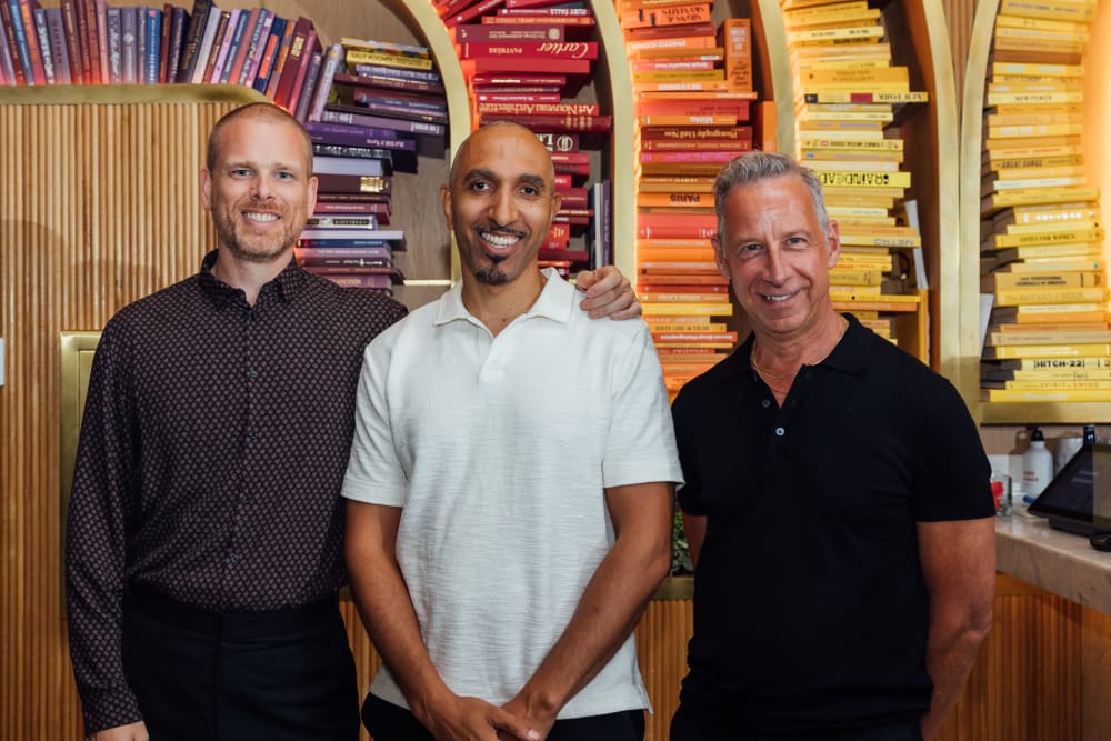 Jonathan, John and Gregg standing next to each other smiling into the camera. 