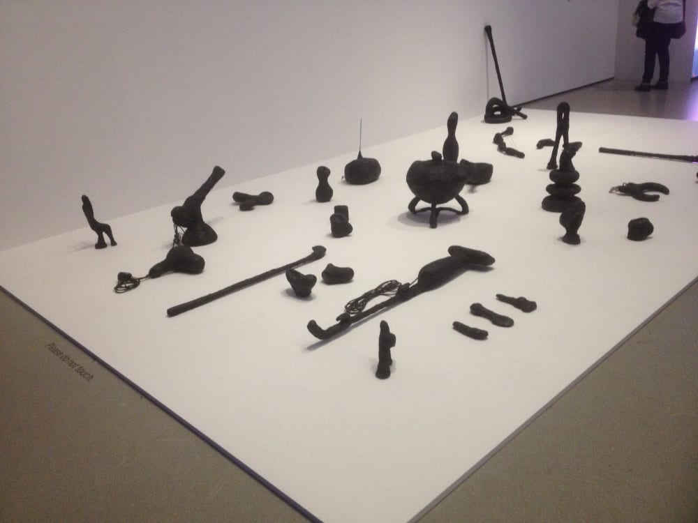 installation shot of camille henrot's sculpture piece augmented objects featuring a number of objects in black