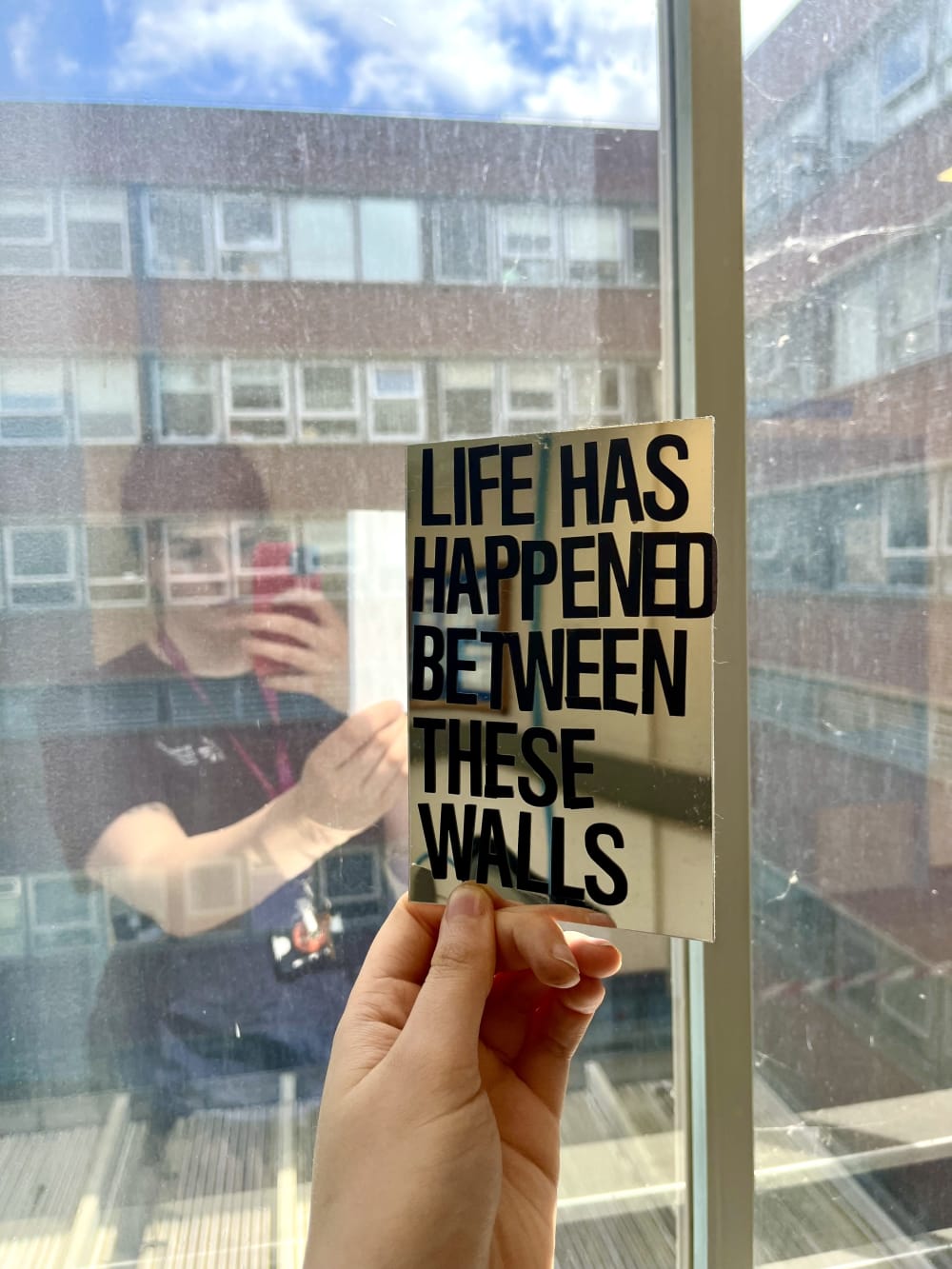 BA Sculpture student Phoebe Kaniewska holding up a mirrored card with the words 