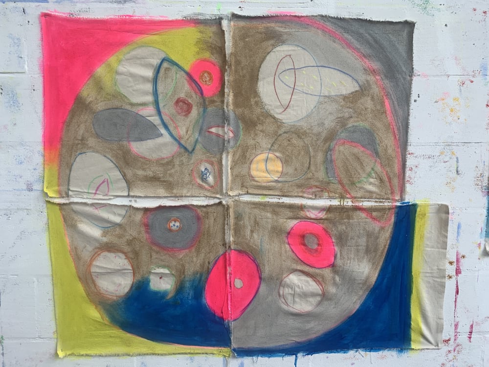 4 pieces of canvas placed together to create a whole picture. A large circle with round shapes in the middle