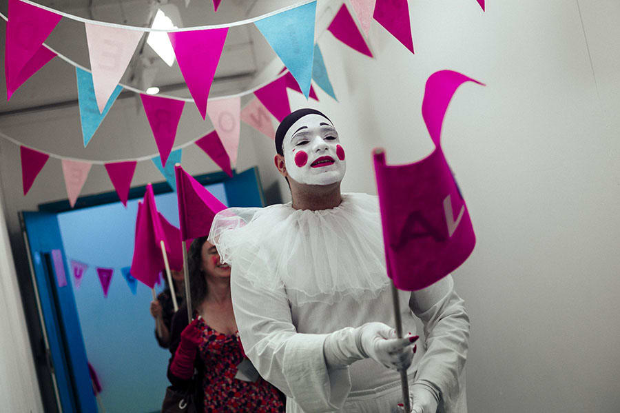 A mime holding a pink flag.