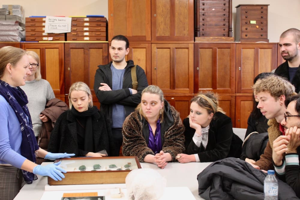 museum curator showing students archival objects