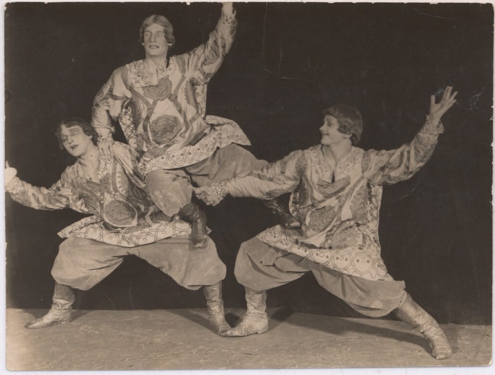 Sepia photograph of three dancers in costume