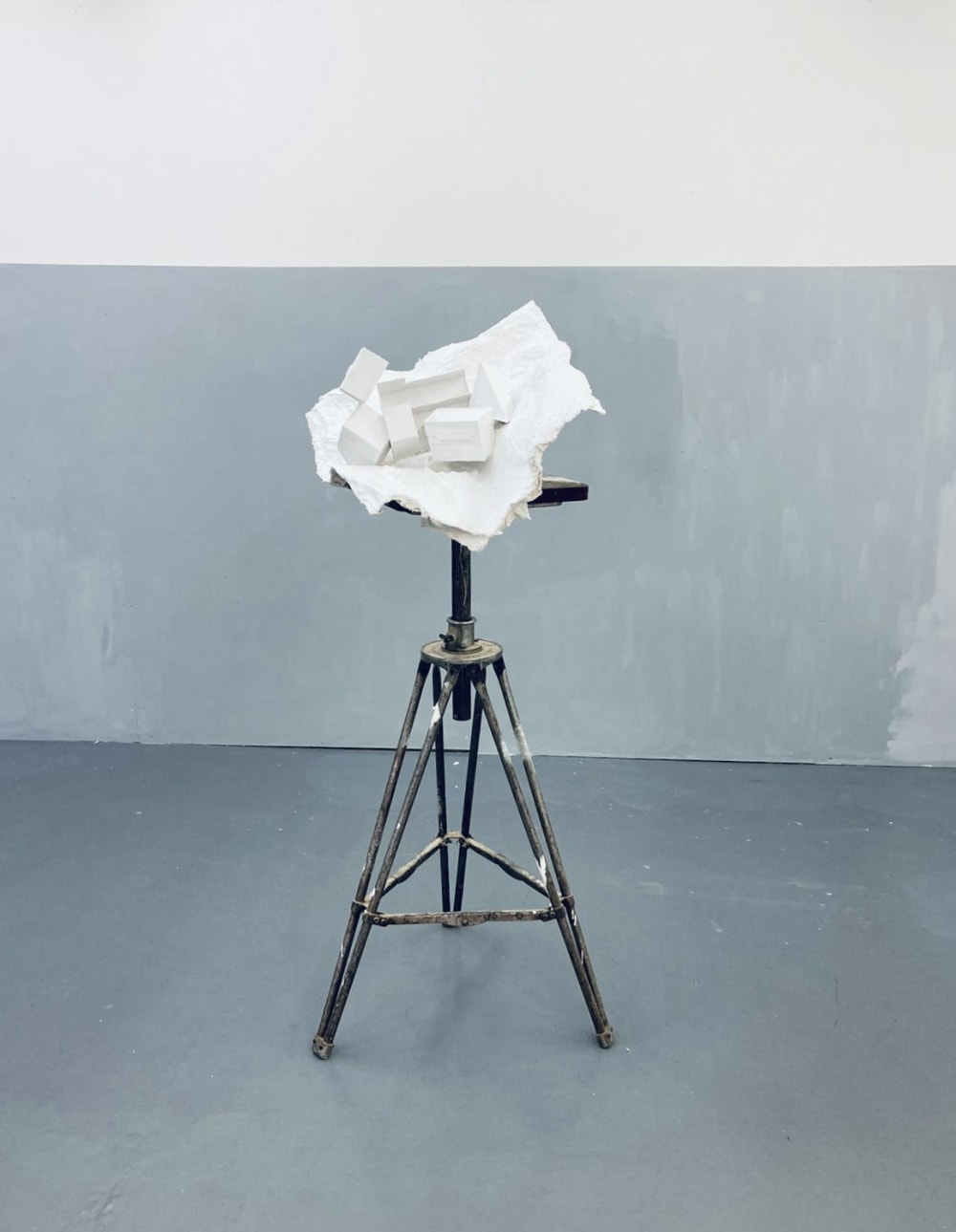 White sculpture on paint covered tripod