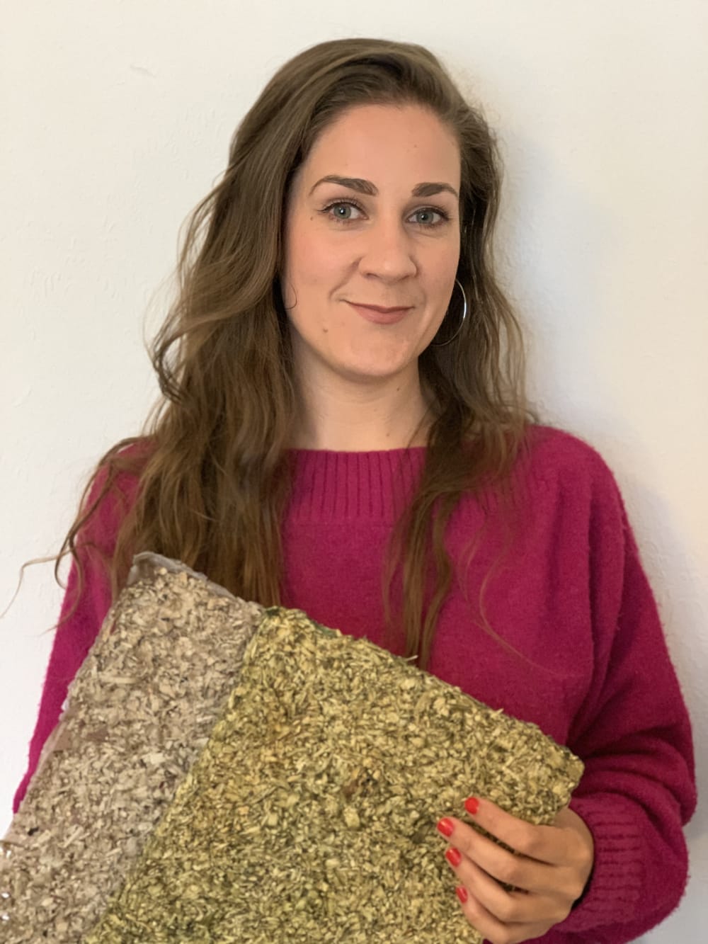 Photo of Zoe holding a piece of material, and smiling to the camera