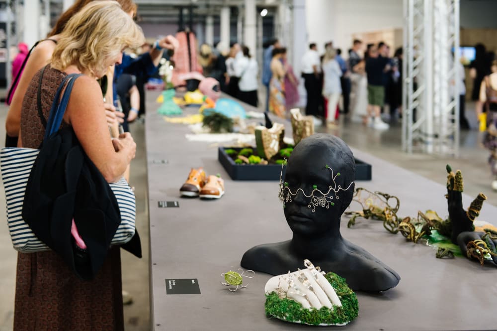 People looking at student sustainable jewellery on table setting