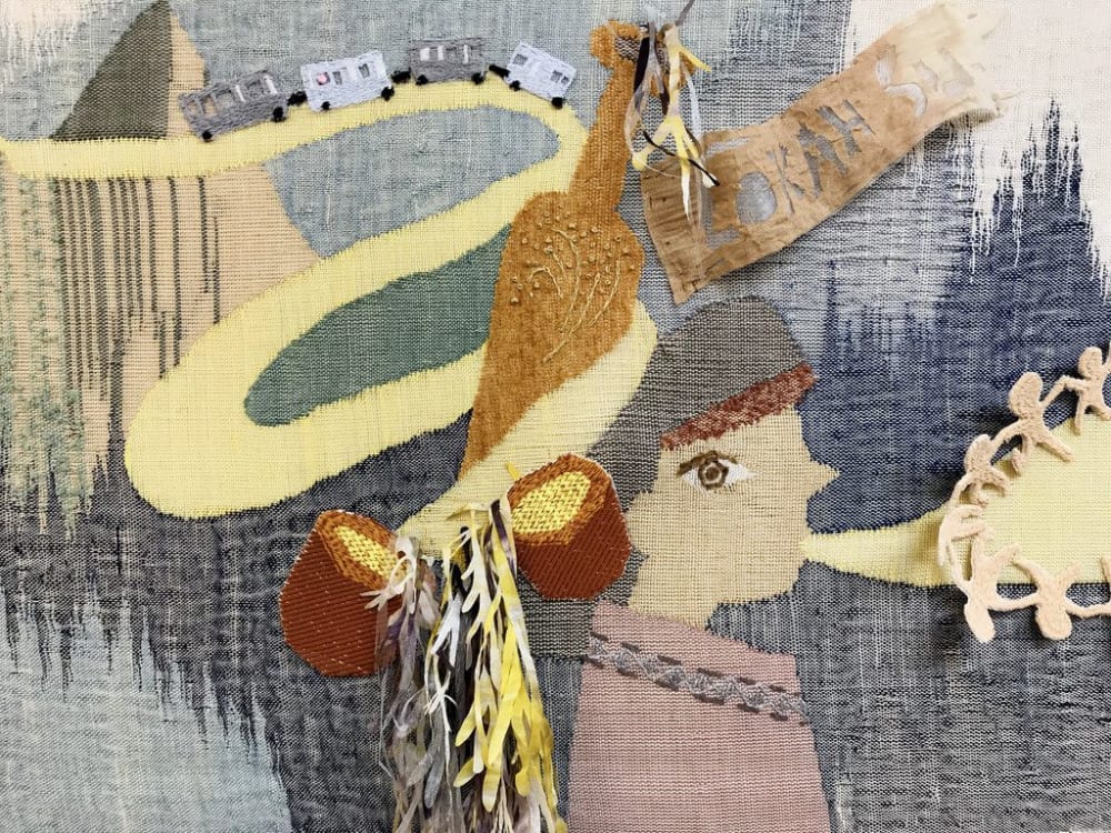 Weaving of a character wearing a hat and blowing a horn.