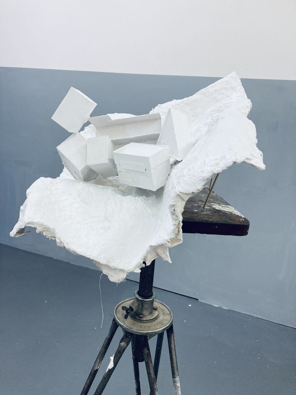 White sculpture of cubes on tripod