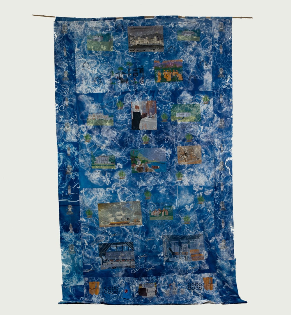A large hanging tapestry. It is mainly blue and white and has intricate scenes of people and places