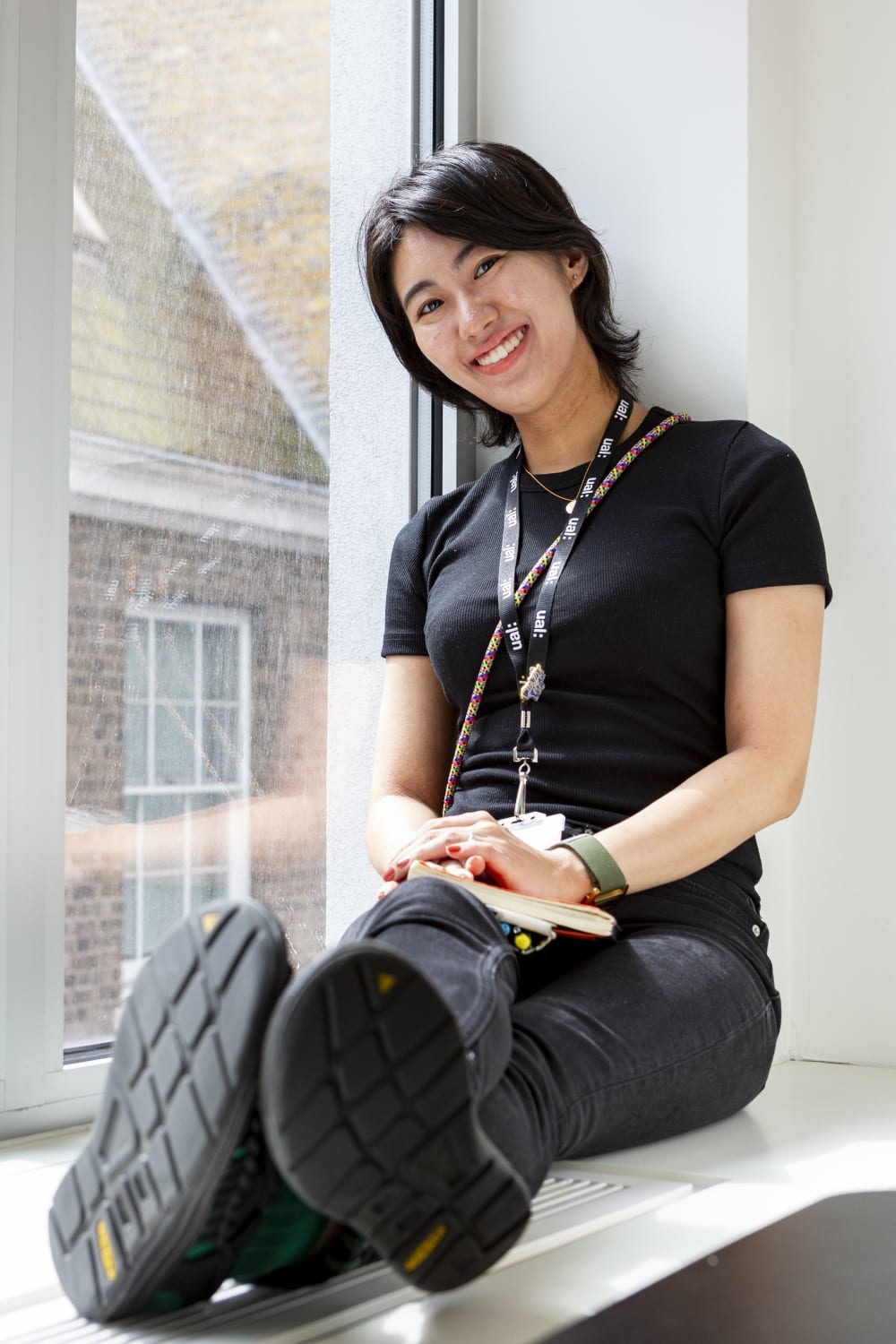 Student sitting in front of a window, smiling