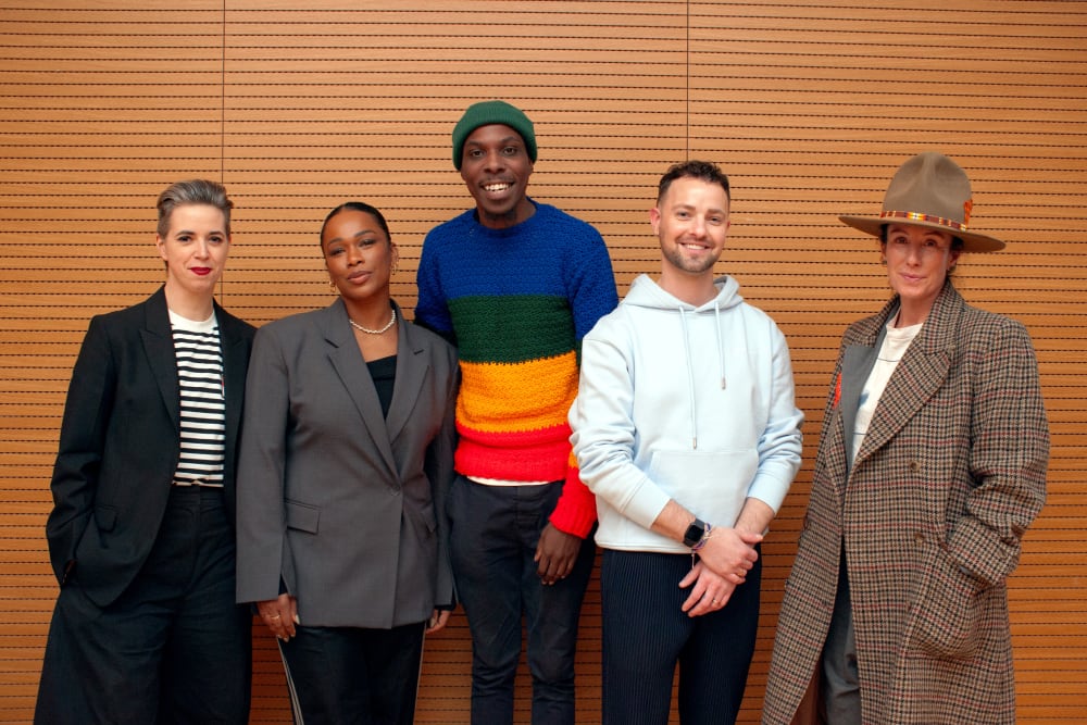 The panellists for the event standing next to each other, smiling to the camera