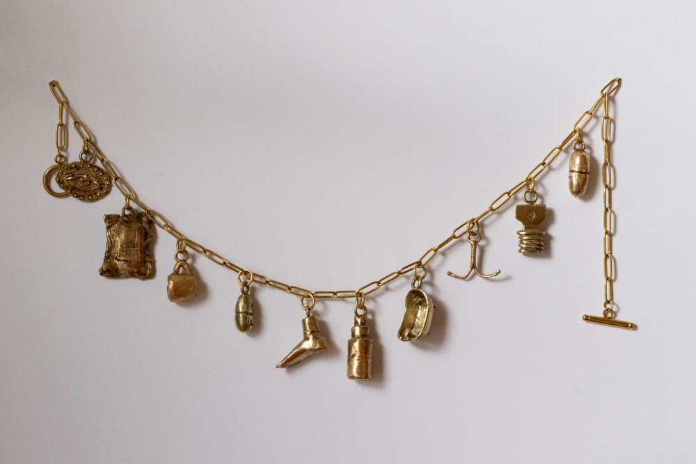 Gold bracelet with charms that explore the theme of women's health attached 