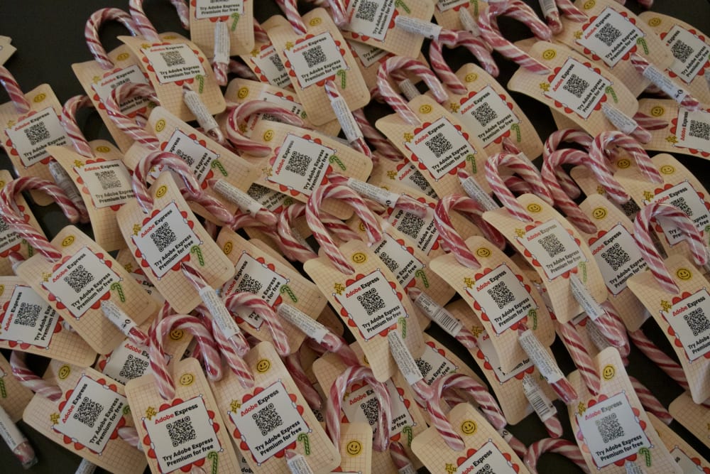 Several pink and white candy canes with 'Adobe Express' wrapping around them.