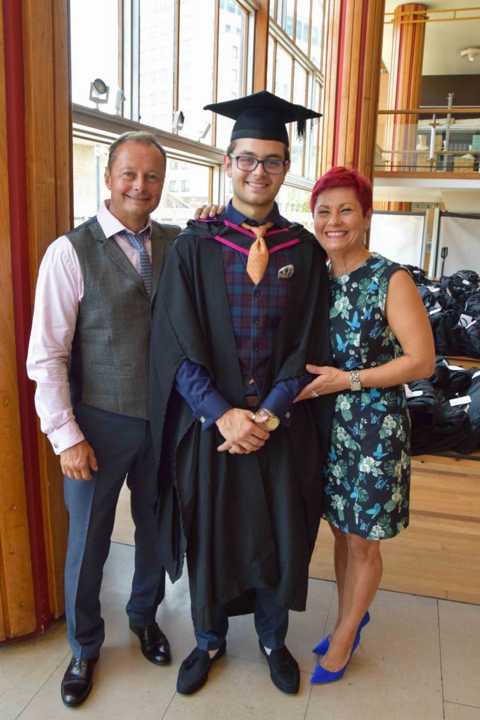 A family portrait of three with the graduating student in the middle.