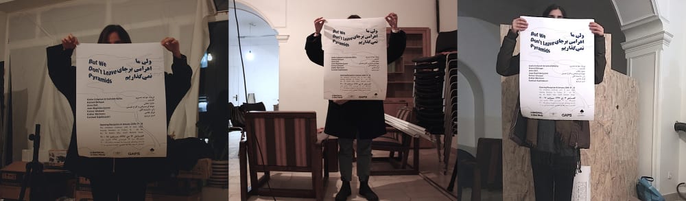 Three curators cover their faces with the exhibition poster