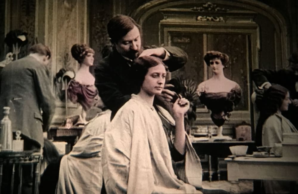 Man cutting seated woman's hair