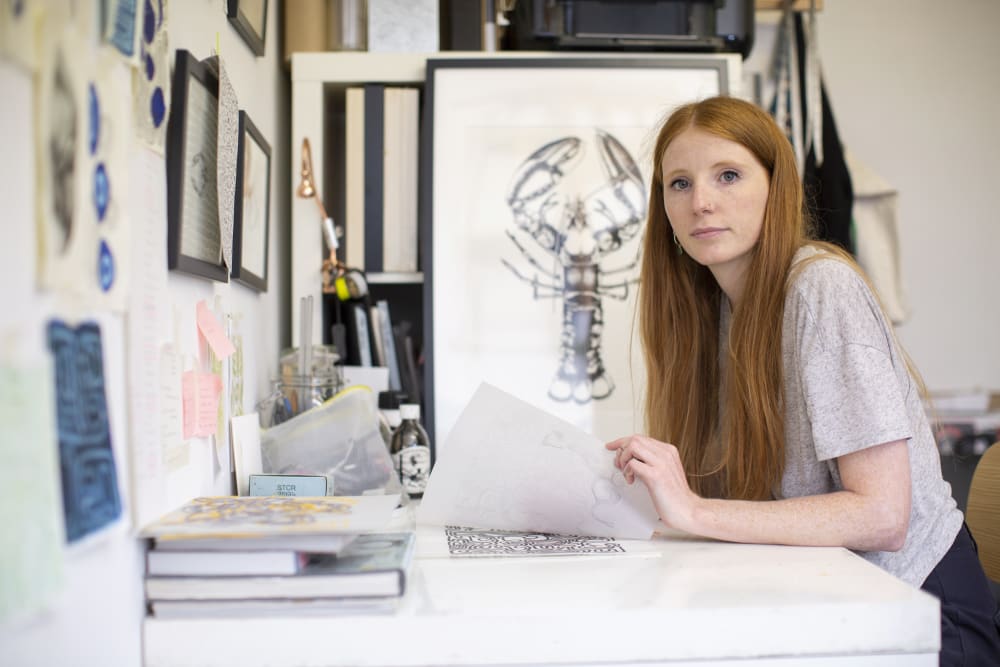 Photo of Anoushka in her workshop with sketches around