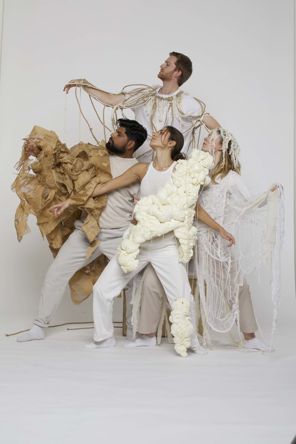 Figures alll dressed in whites and neutrals, in similar heightened stances