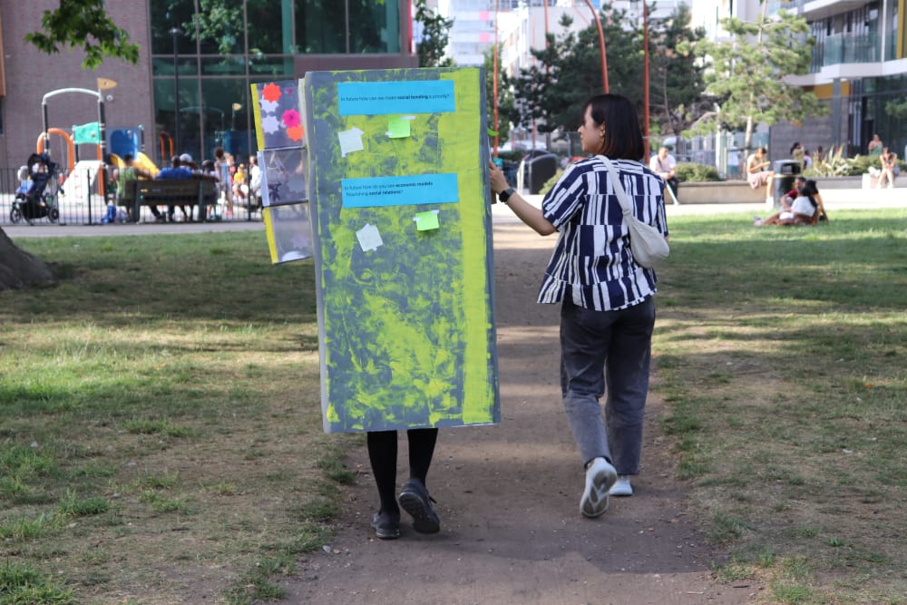a person wearing a box being led by another person walking them along a path