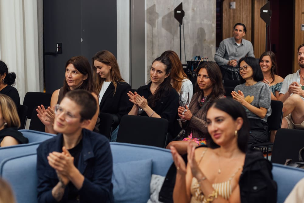 Guests at the event sitting in rows. Some of them are clapping their hands